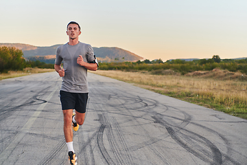 Image showing A young handsome man running in the early morning hours, driven by his commitment to health and fitness