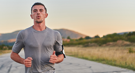 Image showing A young handsome man running in the early morning hours, driven by his commitment to health and fitness