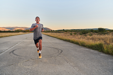 Image showing A young handsome man running in the early morning hours, driven by his commitment to health and fitness