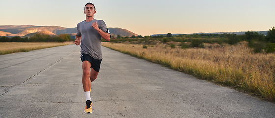 Image showing A young handsome man running in the early morning hours, driven by his commitment to health and fitness
