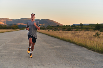 Image showing A young handsome man running in the early morning hours, driven by his commitment to health and fitness