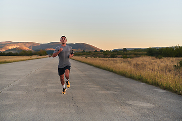 Image showing A young handsome man running in the early morning hours, driven by his commitment to health and fitness