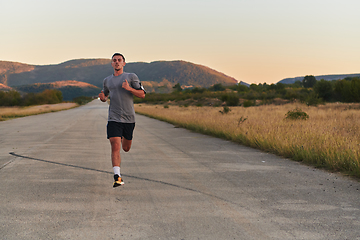 Image showing A young handsome man running in the early morning hours, driven by his commitment to health and fitness