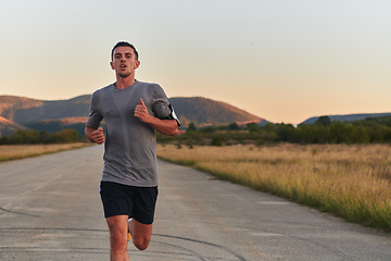 Image showing A young handsome man running in the early morning hours, driven by his commitment to health and fitness