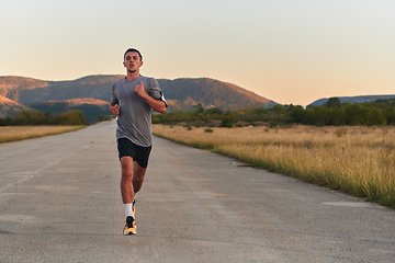 Image showing A young handsome man running in the early morning hours, driven by his commitment to health and fitness