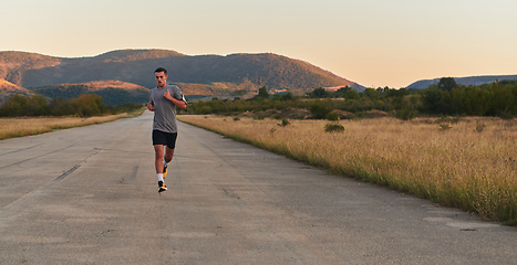 Image showing A young handsome man running in the early morning hours, driven by his commitment to health and fitness