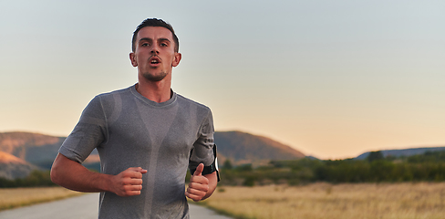 Image showing A young handsome man running in the early morning hours, driven by his commitment to health and fitness