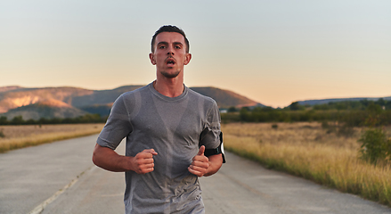 Image showing A young handsome man running in the early morning hours, driven by his commitment to health and fitness