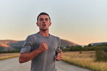 Image showing A young handsome man running in the early morning hours, driven by his commitment to health and fitness