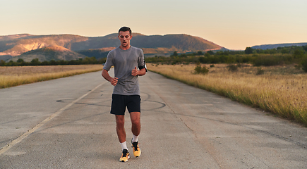 Image showing A young handsome man running in the early morning hours, driven by his commitment to health and fitness