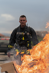 Image showing Close-up portrait of a heroic fireman in a protective suit. Firefighter in fire fighting operation.