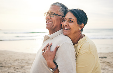 Image showing Love, hug and senior couple at beach happy, relax and bond in nature together. Ocean, embrace and old people hugging at the sea for travel, vacation and enjoy retirement with holiday, freedom or trip