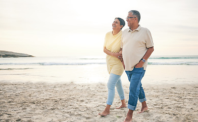 Image showing Love, walking and senior couple at the beach happy, relax and bond in nature together. Ocean, embrace and old people at the sea for travel, vacation and enjoy retirement with holiday, freedom or walk