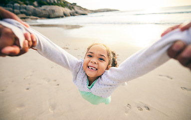 Image showing Happy, spin and portrait of child at the beach for travel, support and fun. Swinging, smile and summer with girl and holding hands with family together for vacation, trust and seaside holiday