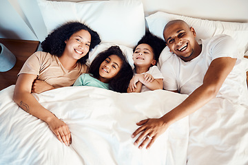 Image showing Top view, bed and family with love, portrait and quality time with happiness, apartment and bonding. Parents, mother and father with children, kids and morning in a bedroom, funny and loving together
