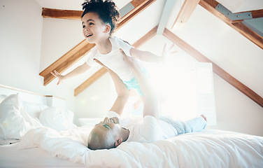 Image showing Man, young girl in air and games in bedroom, airplane and care free with bonding, love and happiness at family home. Father lifting daughter, playing together with fun and playful, trust and flying