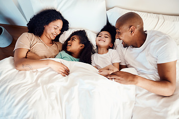 Image showing Top view, bed and family with love, laughing and funny happiness, bonding and loving together. Parents, mother or father with children, kids and cheerful in a bedroom, humor and quality time with joy