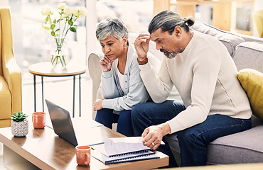 Image showing Senior couple, laptop and financial crisis on sofa with documents in budget struggle or debt at home. Frustrated elderly man and woman with computer for finance, bills or expenses in the living room