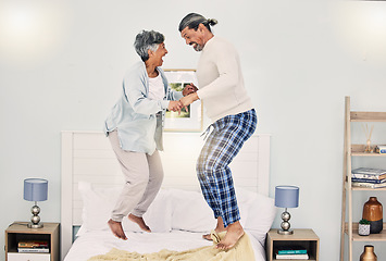 Image showing Happy, playful or old couple jumping on bed to relax, enjoy holiday or fun morning together at home. Playing, silly senior woman or elderly man laughing or bonding with love or smile in retirement