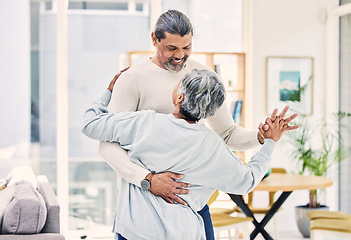 Image showing Senior couple, hug and holding hands in dancing for love, care or bonding together in living room at home. Happy elderly man and woman enjoying quality time, retirement or celebration for anniversary