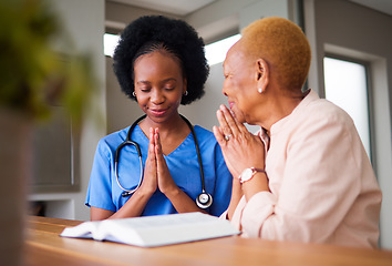 Image showing Healthcare, black woman nurse and patient praying together while reading the bible in an old age home. Medical, trust or faith with a female medicine professional and senior adult talking to God