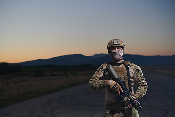 Image showing A professional soldier in full military gear striding through the dark night as he embarks on a perilous military mission