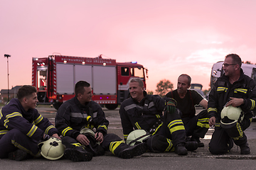 Image showing Brave Firefighters Team Walking to the Camera. In Background Paramedics and Firemen Rescue Team Fight Fire in Car Accident, Insurance and Save Peoples Lives concept.