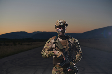 Image showing A professional soldier in full military gear striding through the dark night as he embarks on a perilous military mission