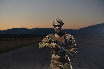 Image showing A professional soldier in full military gear striding through the dark night as he embarks on a perilous military mission