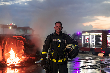 Image showing Portrait of a heroic fireman in a protective suit. Firefighter in fire fighting or car accident rescue operation in dusk or night.