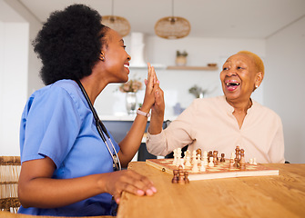 Image showing Caregiver playing chess with an elderly patient after healthcare consultation in nursing rehabilitation center. Board game, high five and female nurse bonding with senior woman in retirement home.