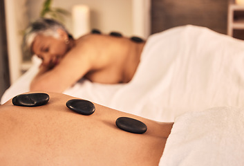 Image showing Closeup, spa and stone massage on back of people for skincare cosmetics, holistic therapy and muscle healing at beauty salon. Relax, wellness resort and self care of hot rocks for zen, peace or detox