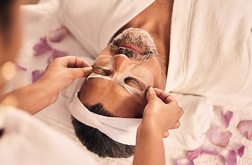 Image showing Wellness, eye mask and mature man at a spa for health, self care and zen treatment. Relax, calm and masseuse hands doing a beauty facial massage routine on a senior male person at luxury peace salon.