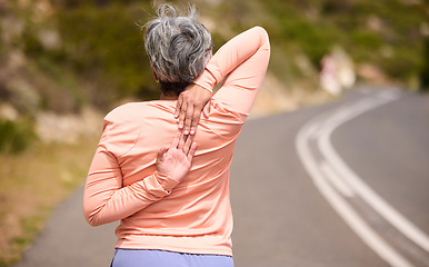 Image showing Senior woman runner, stretching back and training in street, nature and exercise for wellness in retirement. Mature lady, running and workout on countryside road, mountains and warm up muscle outdoor