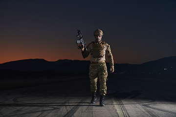 Image showing A professional soldier in full military gear striding through the dark night as he embarks on a perilous military mission