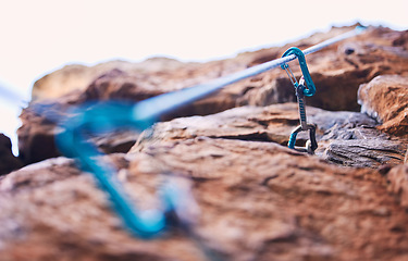 Image showing Rock climbing, mountain and closeup of rope and hook for adventure, freedom and extreme sports in nature. Fitness, hiking and carabiner, equipment or gear in stone for training, activity or challenge