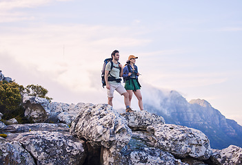 Image showing Mountain, hiking view and man with woman on peak for adventure in nature, landscape and travel. Outdoor trekking, couple on cliff and relax in scenic clouds for natural journey, walking and looking.