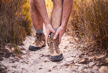 Image showing Hiking, injury and shoes of man in nature for leg pain, training and accident. Emergency, healthcare and inflammation with closeup of person walking on path for muscle, trekking and problem