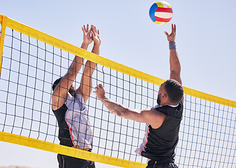 Image showing Beach, volleyball and team with competition at ocean and sea with exercise, sport and fitness. Summer, outdoor and training people playing for health, action games and workout with ball in nature