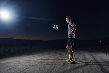 Image showing Portrait of a young handsome soccer player man on a street playing with a football ball