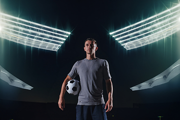 Image showing Portrait of a young handsome soccer player man on a street playing with a football ball.