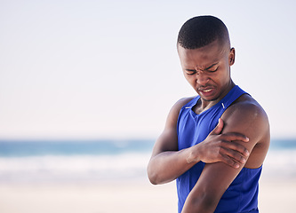 Image showing Sports, arm pain and man at a beach for exercise, fitness and training with problem. Shoulder, injury and African person with arthritis, fibromyalgia or osteoporosis during workout on mockup space