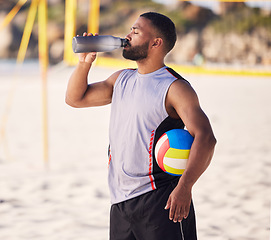 Image showing Volleyball, drinking water and fitness of man on beach for training, competition and outdoor game break. Tired, handball and athlete or person with sports bottle on sand in summer or holiday wellness