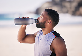 Image showing Beach, exercise and man drinking water after running, workout or cardio fitness for health. Hydration, drink and thirsty male and runner person with bottle at sea for training, wellness or sports