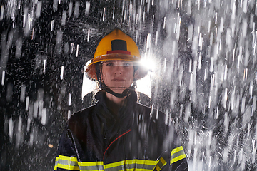 Image showing A determined female firefighter in a professional uniform striding through the dangerous, rainy night on a daring rescue mission, showcasing her unwavering bravery and commitment to saving lives.