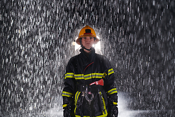 Image showing A determined female firefighter in a professional uniform striding through the dangerous, rainy night on a daring rescue mission, showcasing her unwavering bravery and commitment to saving lives.