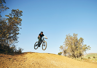 Image showing Downhill, mountain bike and man outdoor in nature for extreme sports, training or workout. Hill, countryside and male person with courage or bicycle stunt for off road cycling, travel or adventure