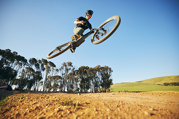 Image showing Jump, mountain bike and man outdoor in nature for extreme sports, training or workout. Sky, air or wellness of male person with courage or bicycle stunt for off road cycling, travel or adventure