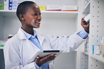 Image showing Black woman, pharmacist and tablet at medicine shelf for stock check in pharmacy, drugstore or shop. Medical professional, inventory and happy doctor with tech, pills or supplements for healthcare.