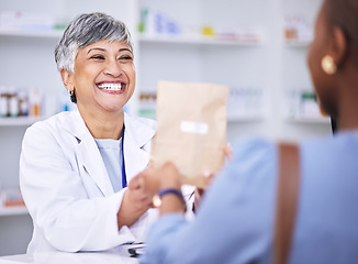 Image showing Happy woman, pharmacist and medication for patient prescription over the counter at the pharmacy. Female person, medical or healthcare professional giving customer pills or pharmaceutical package